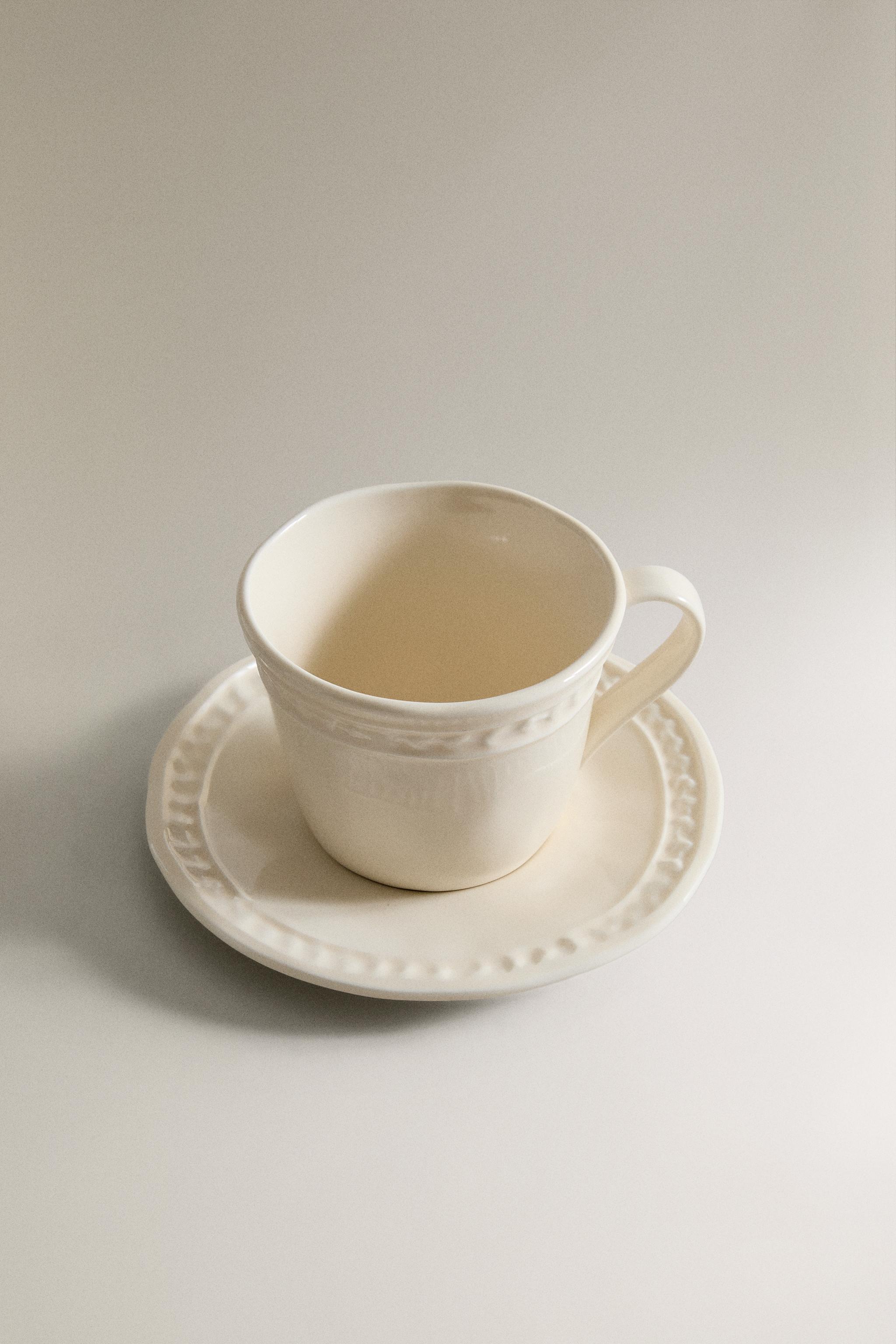 STONEWARE RAISED DESIGN COFFEE CUP AND SAUCER
